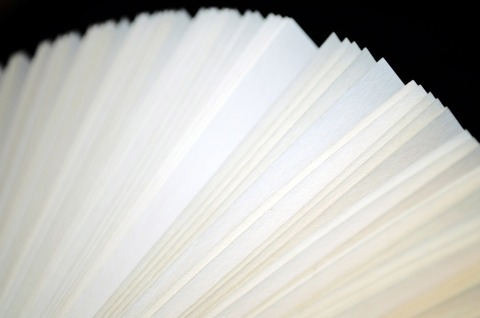 Buchseiten eines aufgeklappten Buchs vor schwarzem Hintergrund